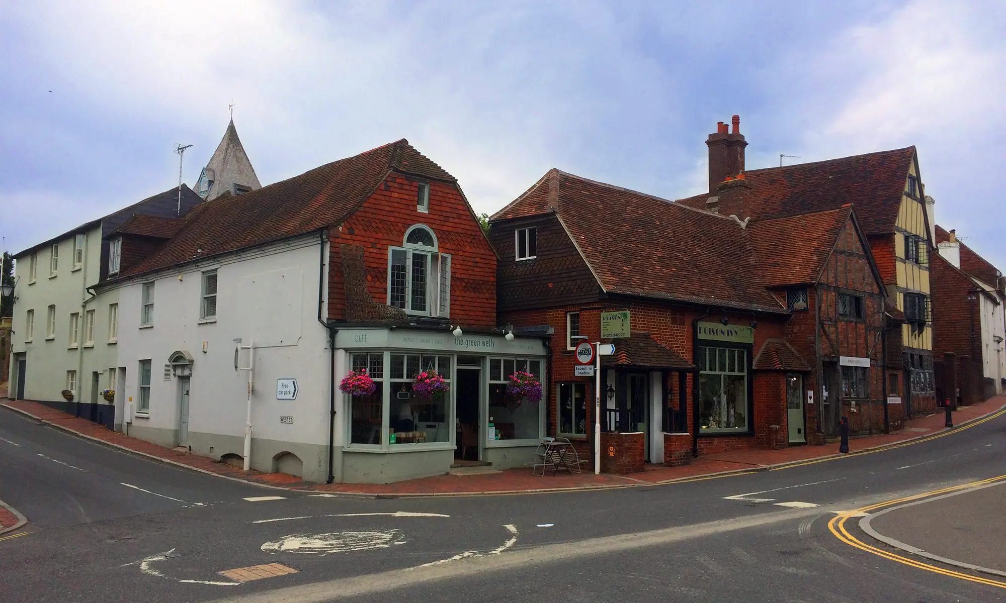A scenic view of Ditchling village high street featuring historic brick buildings and local pubs near the South Downs, East Sussex.