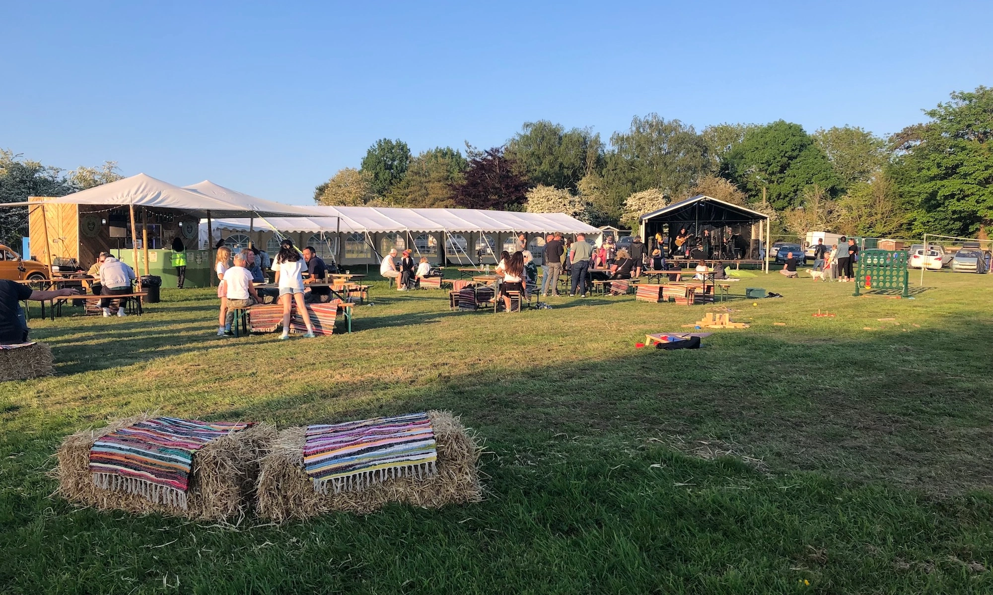 People enjoying an outdoor beer festival with live music and marquees at Ditchling Camping